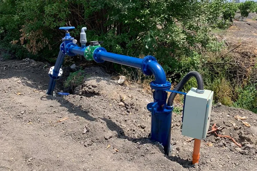Cabezal de pozo profundo con cañería, válvula y tablero instalado por Well Pumps en terreno